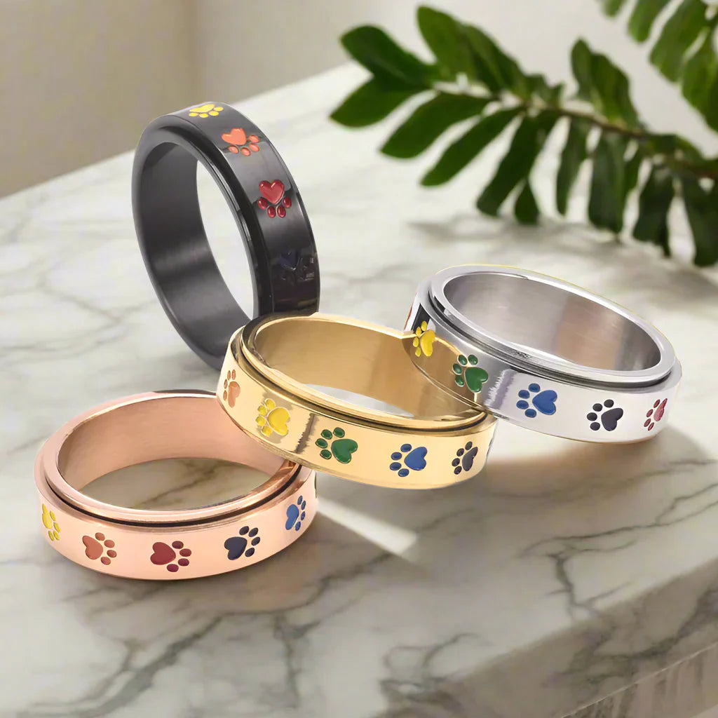 Rotativ Antistressring i Guld och Silver med Färgade Tassmönster – Thea